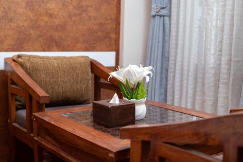 a table with a vase of flowers and a box on it at Royal Boutique Hotel in Kathmandu