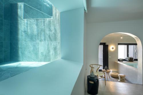 a bathroom with a tub and a sink and a mirror at Melidonia Suites in Akrotiri