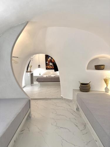 Petuna Cave Suites في فيرا: غرفة نوم بجدران بيضاء وسرير في غرفة