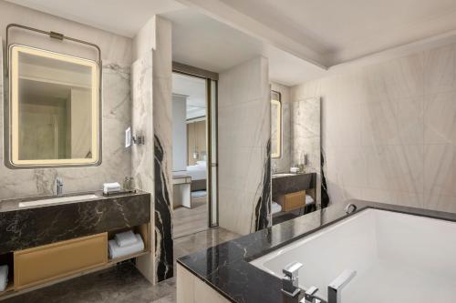 a bathroom with a tub and a sink at Navi Mumbai Marriott in Navi Mumbai