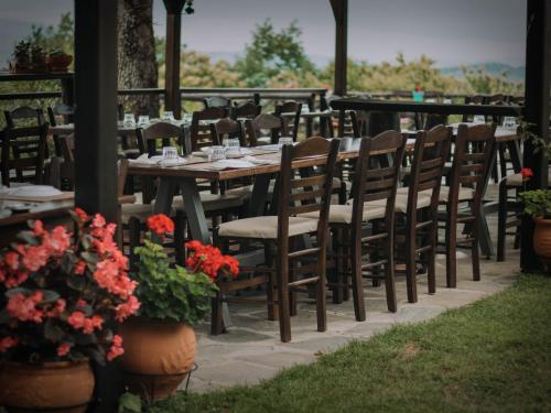 a wooden table and chairs on a patio with flowers at Μαγεμένο Δάσος Apartments in Neokhórion