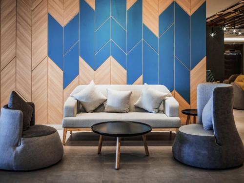 a living room with a couch and two chairs at ibis Styles Kota Bharu in Kota Bharu