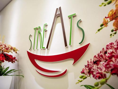a sign on a wall with flowers at ibis Styles Kota Bharu in Kota Bharu