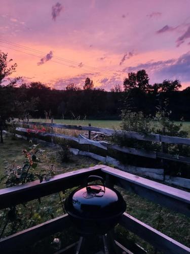 a sunset over a fence with a bird feeder on it at Au chant des oiseaux - rouge gorge in Varen