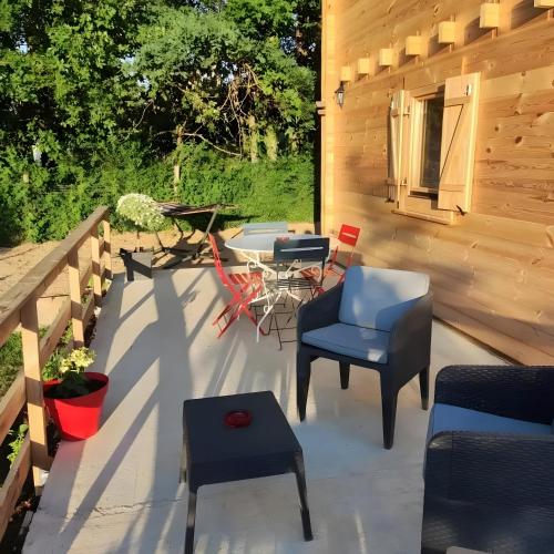 a patio with a blue chair and a table at Au chant des oiseaux - rouge gorge in Varen