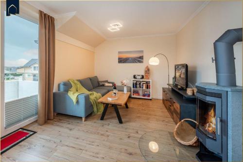 ein Wohnzimmer mit Couch und Kamin in der Unterkunft Ückeritz Sylva in Ückeritz