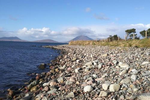 a large group of rocks on the shore of the water at Nature Retreat - Sleeps 4 & Wild Ponies in Tullaghanbaun
