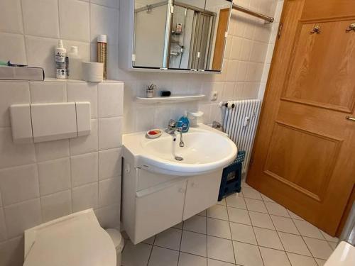 ein weißes Badezimmer mit Waschbecken und Toilette in der Unterkunft Bergblick in Farchant