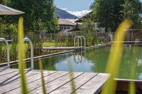 a swimming pool in a yard with a wooden deck at Beim Nuihausa in Reit im Winkl