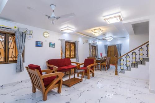 a living room with chairs and a table and stairs at 4Bedroom Villa With shared pool in Nerul
