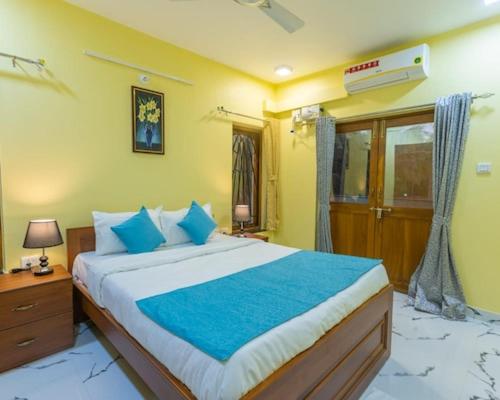 Un dormitorio con una cama grande con almohadas azules. en 4Bedroom Villa With shared pool, en Nerul