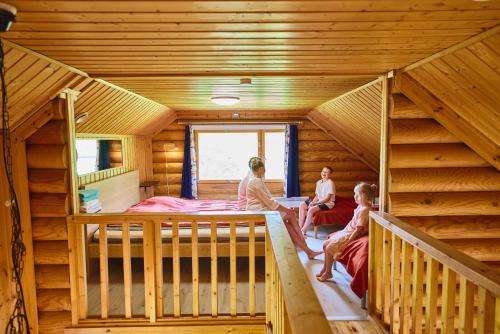 three people sitting in a room in a log cabin at Serena Villas in Espoo