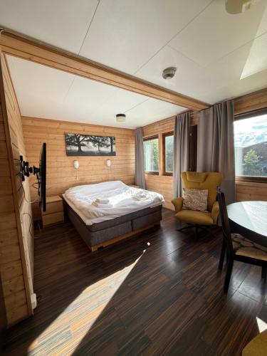 a bedroom with a bed and a chair and a table at Sandmoen Bed & Breakfast, Free Parking in Trondheim
