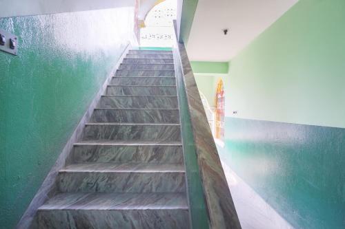 a staircase in a room with a green wall at Hotel O New Heaven in Murshidābād