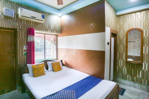 a bedroom with a bed with yellow and blue pillows at Hotel O New Heaven in Murshidābād