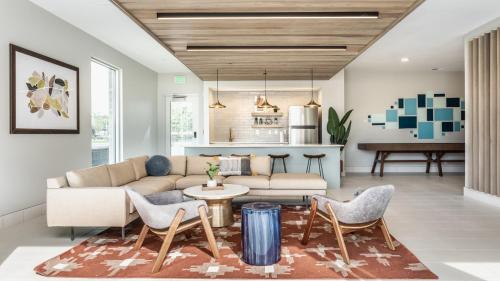 a living room with a couch and chairs and a table at CozySuites AYR in Indianapolis
