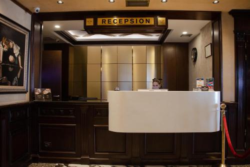 a woman sitting at a reception desk in a room at Hotel Chicago in Shkodër