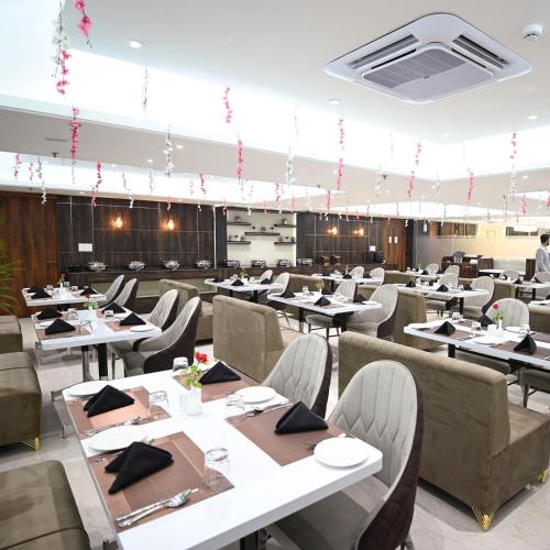 a dining room with tables and chairs in a room at Celestial Casa in Lucknow