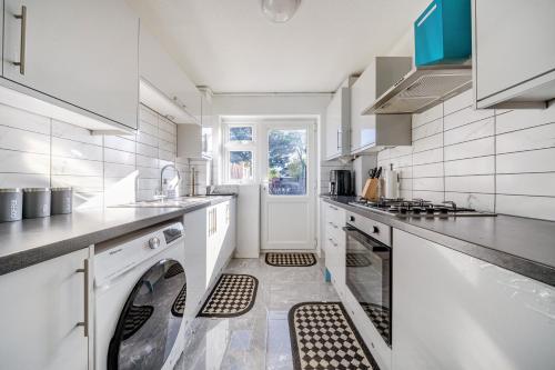 a large white kitchen with a washer and dryer at Luxury 3-Bedrooms House With Parking in Abbey Wood