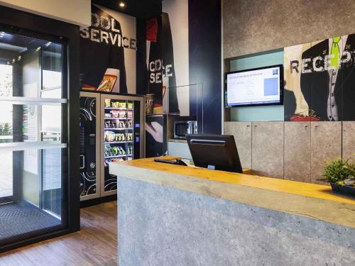 a bar in a store with a laptop on the counter at Ibis Budget Mulhouse Centre Gare in Mulhouse