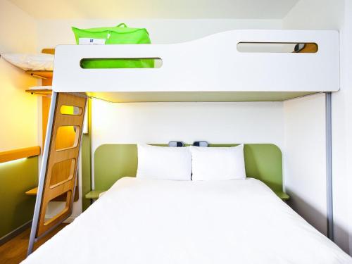 a bunk bed in a small room with a white bed at Ibis Budget Sarrebourg Buhl in Sarrebourg