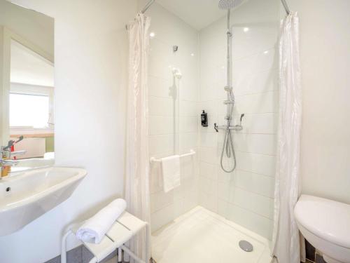 a white bathroom with a shower and a sink at Ibis Budget Sarrebourg Buhl in Sarrebourg