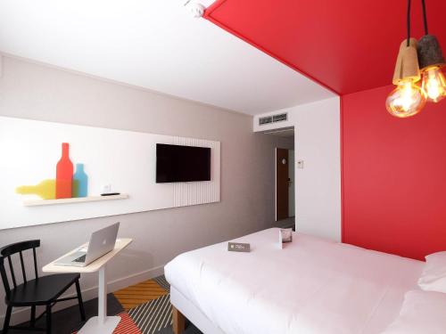 a bedroom with a white bed and a red wall at Hôtel ibis Styles Auxerre Nord in Auxerre