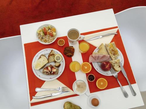 a table topped with plates of food and drinks at Hôtel ibis Styles Auxerre Nord in Auxerre