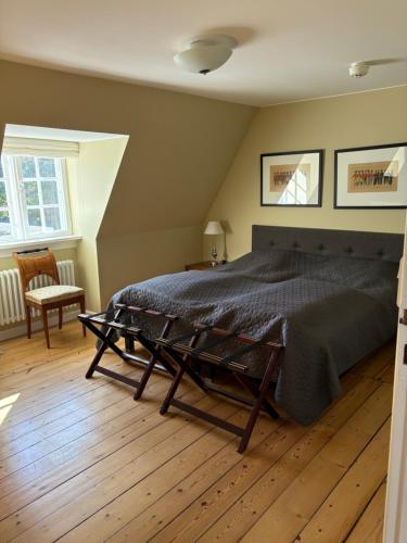 a bedroom with a large bed with a wooden floor at Risinge Herregård in Ullerslev