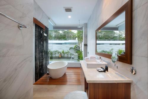 a bathroom with a large tub and a large window at The Daha Luxury Villas in Seminyak