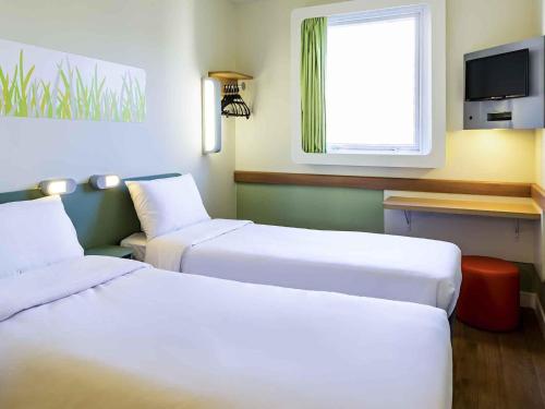 a hotel room with two beds and a window at ibis budget RJ Praia de Botafogo in Rio de Janeiro