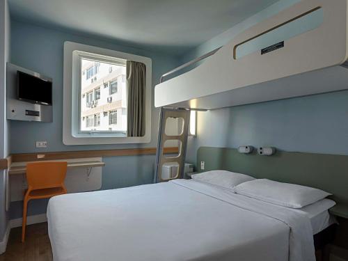 a bedroom with a large white bed and a window at ibis budget RJ Praia de Botafogo in Rio de Janeiro