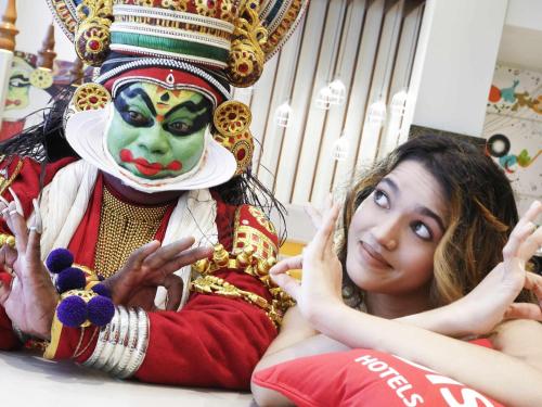 a woman sitting next to a man wearing a mask at ibis Kochi City Centre - An Accor Brand in Cochin