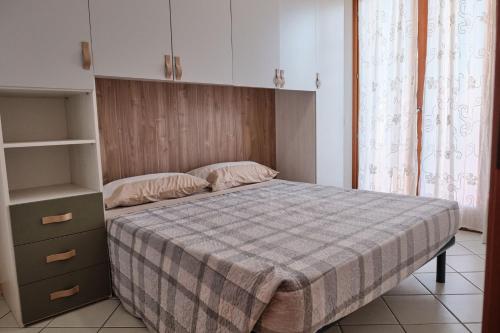 a bedroom with a bed with a checkered blanket at Relaxing escape flat-Beahost in Rosapineta