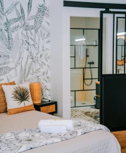 a bedroom with a bed with a tropical wallpaper at Hôtel Restaurant La Caravelle in Sari Solenzara
