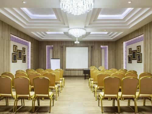 a conference room with chairs and a whiteboard at ibis Yogyakarta Adi Sucipto in Yogyakarta