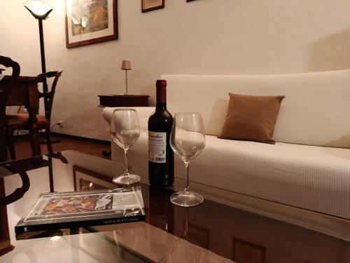 a bottle of wine and two glasses on a table at Casa dell' Onda 25 in Siena