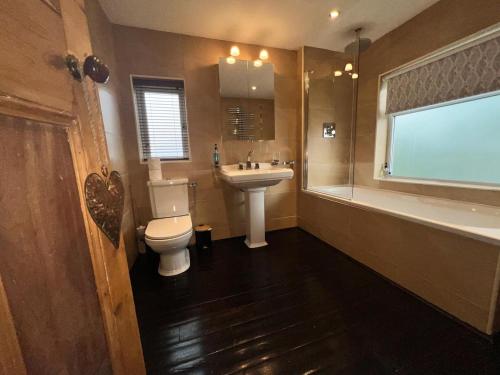a bathroom with a toilet and a sink and a tub at Beach Hill House - Rhos on Sea in Colwyn Bay