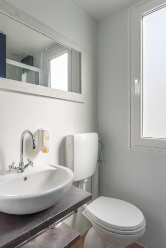 a bathroom with a white sink and a toilet at Maistra Camping Veštar Mobile homes in Rovinj
