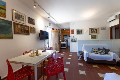 un soggiorno con tavolo, sedie e divano di Vicinissima alla spiaggia della Pelosa a Stintino