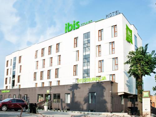 a white building with a sign on top of it at Ibis Styles Gniezno Stare Miasto in Gniezno