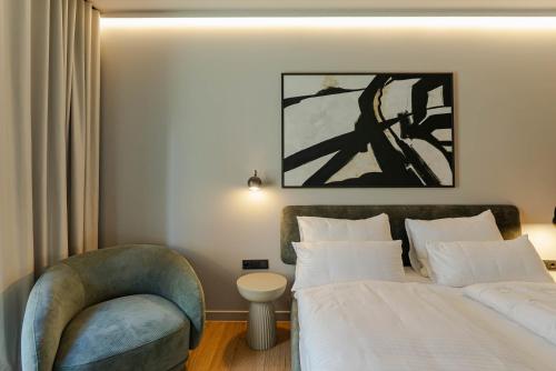 a hotel room with a bed and a chair at Conlon House Lower East Side in Munich