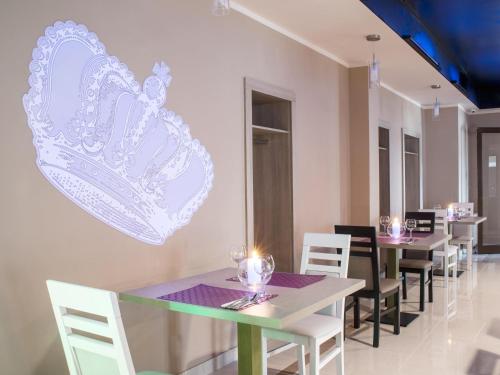 a dining room with tables and chairs and a heart on the wall at Ibis Styles Gniezno Stare Miasto in Gniezno