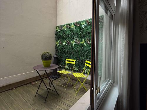 a room with a table and chairs and a green wall at ibis Styles Paris Mairie De Clichy in Clichy