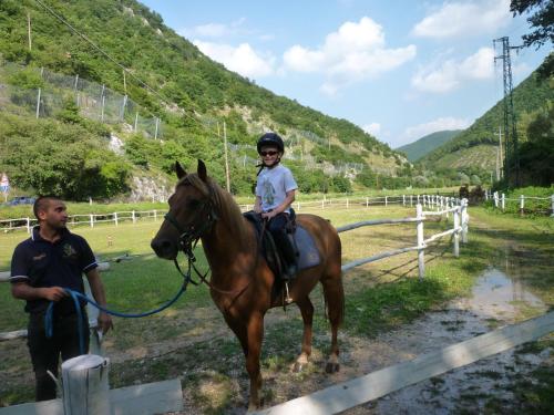 a young boy riding a horse next to a man at Guesia Village Hotel e Spa in Foligno