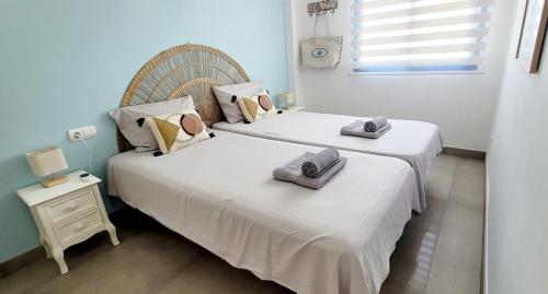 two beds in a room with towels on top of them at Blue Beach Apartment in Ifach