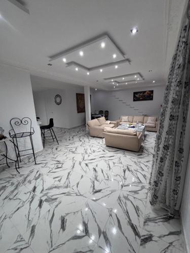 ein Wohnzimmer mit einem Marmorboden und einem Sofa in der Unterkunft cottage with swimming pool in Raoued