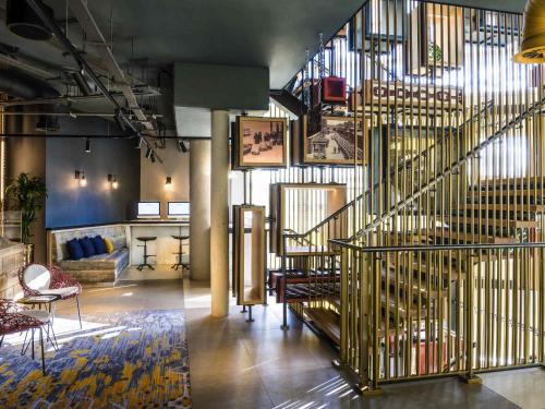 a lobby with a staircase and a living room at Novotel London Canary Wharf in London