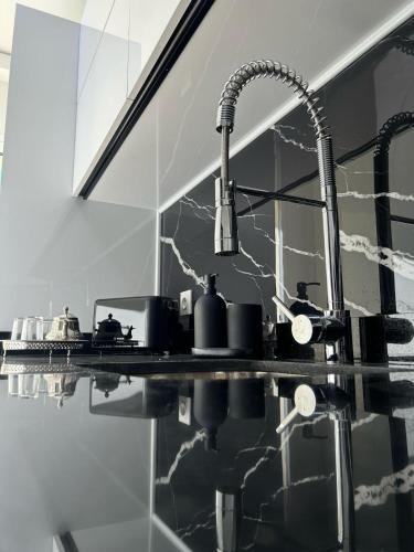 a black and white kitchen with a sink and mirror at Modern 2BR Apartment Tangier Center with Air Conditioning and WiFi in Tangier