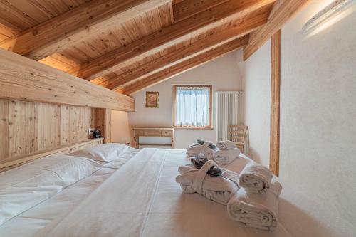 - une chambre avec un grand lit blanc et des plafonds en bois dans l'établissement Chalet Dolomites Heart, à Feder